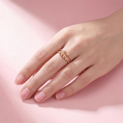 Frauenhand mit Fidget Beads Ring Gold am Ringfinger