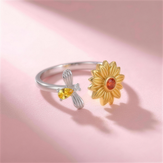Bee Ring – verstellbarer Ring mit Sonnenblume und Biene, liegend auf rosa Hintergrund, Seitenansicht
